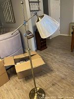 Full side view of brass adjustable floor lamp with shade, showing height and overall design.