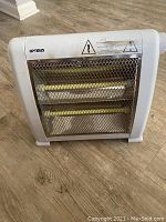 Front view of a white Optimus space heater featuring a metal grid over the heating elements and the brand name visible on top left.