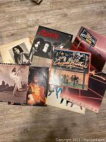 Photo showing seven of the ten vintage vinyl record album covers arranged on a floor, includes Ronin, Missouri, Cooper Brothers, Temptation, and others.
