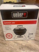 Photo of Weber Smokey Joe grill packaging showing brand name, grill size 14 inches and charcoal grill label.