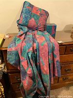 Fabric swags, pillow, and tissue box placed on a wooden dresser, showing the colorful geometric pattern and fabric texture.