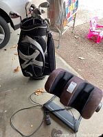 View showing golf bag with clubs and massager side by side