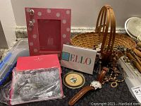 Overall view of lot including pink polka dot photo frame, beaded necklaces, wristwatch, framed floral artwork, Kate Spade notebook box and bag
