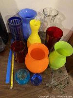 Front view showing the vases and votive holders arranged on a surface with measuring tape for scale.