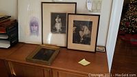 Main shot of four framed wall art pieces on wooden cabinet