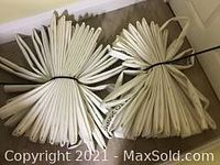 Two lengths of coiled, flat white fire hose bound in neat bundles.