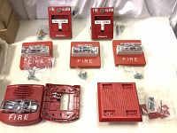 Seven red fire alarm devices from Simplex, including two pull stations and five fire strobe units, all new in box with mounting screws included.
