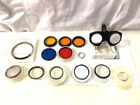 Arrangement of various camera filters with different colors and sizes displayed on white surface