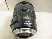 Side view of Canon EF 28-135mm lens showing zoom and macro markings, Image Stabilizer label, and silver lens mount.