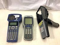 Three devices: Brady BMP21 label printer with keyboard and screen, Brady CK30 label printer with buttons and screen, and black Psion barcode scanner handle only.