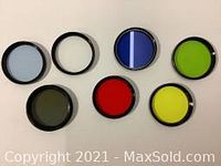 Top-down view of six circular filters showing different colored glass elements including blue, green, red, yellow, and two clear filters.