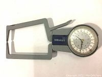 Top view of the Mitutoyo dial caliper gauge showing the frame and dial face with brand name visible