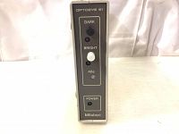 Front view of the Mitutoyo Optoeye E1 controller showing control panel with buttons for Dark, Bright, Adjust, and Power with LED indicators.