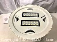 Top view of white LED high bay light with two LED arrays and sensor on top.