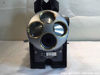 Front view of microscope head showing silver rotating turret with 3 circular lens openings.