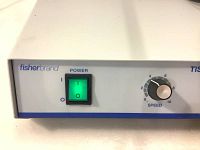 Close-up of Fisherbrand power switch with green power light illuminated and speed dial showing.