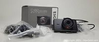 Photo of Apeman C450 dash camera with box and all included mounting and power accessories wrapped in plastic bags.