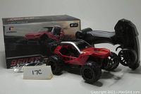 Red and black 1:22 scale Deerc 9604E remote control dune buggy with box, charger and black ergonomic remote controller with wheels and trigger.