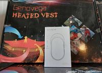 Photo showing boxed Genovega heated vest with thermal heat circulation graphic and a white box of a portable hand warmer with 5200mAh capacity.