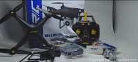 Photo showing JJR/C Bellwether aerial drone, remote controller, batteries, spare propellers, and accessories in front of the product box.