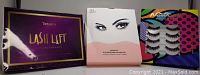 Photo showing three boxed lash kits: Tetyana Lash Lift Kit, Magnetic Eyelash Kit with 5 pairs of lashes and magnetic eyeliner, and False Eyelash Kit with adhesive and 5 pairs of fake lashes.