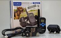 Image showing Petainer branded dog training collar kit with remote, charging cable, plug adapter, and original box.