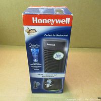 Box packaging of Honeywell Slim Tower Fan showing product details and energy saving features.