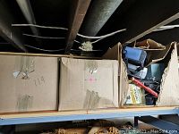 Two large cardboard boxes labeled '114' containing books and assorted items, showing wear and tear on boxes.