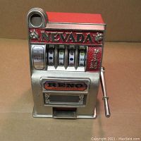 Front view showing Nevada and Reno logos, spinning reels with symbols, and metal lever on right side.