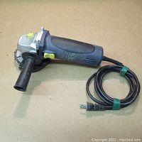 Full view of Power Fist 4.5 inch angle grinder with side handle, power cord coiled