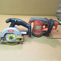 Ryobi cordless circular saw and Black & Decker disc sander side by side showing overall tool condition and cord coiled on sander.
