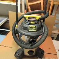 Front angle view of Stanley 5.5 HP 8 Gallon Shop Vac showing the vacuum hose wrapped around the top handle and overall unit.