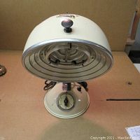 Front view of the vintage Ultrasol lamp showing cream-colored rounded dome head with black knob and reflector inside.