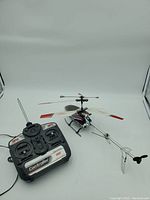 Photo showing remote controlled helicopter and black remote controller