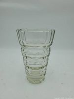 Full front view of clear faceted optic vase showing graduated thick cut bands and shape.