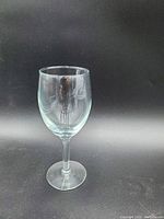 Single clear stemmed wine glass shown against black background to illustrate typical item in lot.