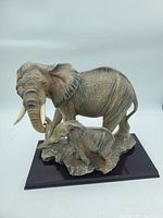 Front and side views of mother elephant with calf on base showing detailed texture and shape