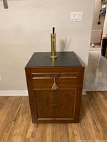Front view of custom Summit kegerator featuring brass tap and wood veneered cabinetry with drawer and door fronts.