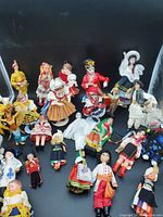 Full view of approximately two dozen colorful play dolls dressed in traditional costumes from various countries around the world.
