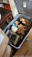 Open plastic bin showing brown bear with blue bowtie, white bear with blue ribbon, and boxed Gund collector's bear.