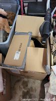 Photo showing cardboard boxes containing chandelier parts and packing material in storage area.
