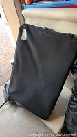 Black collapsible fabric dog crate in folded position showing the front face.