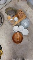 Full view of kitchen items including dishes, wooden salad bowl with tongs, cutting board, knife block without knives, and Cuisinart Mini Mate food chopper.