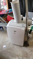 Front view of LG portable air conditioner with exhaust hose attached on top.
