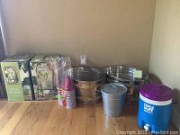 Full lot including two boxed beverage dispensers, two large galvanized buckets, one smaller bucket with lid, blue insulated dispenser, and pack of Solo cups.