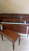 Front and side view of Chickering upright piano and matching bench