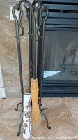 Full view of fireplace tool set including poker, tongs, shovel, brush with natural straw broom, and ceramic holder.