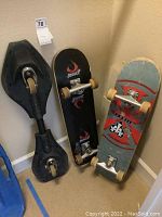 Photo showing three skateboards standing against a wall, Jessup and Elite brands visible, and a third black skateboard with curved shape