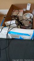 Box with Wii console, steering wheels, cables, and game cases inside