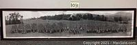 Panoramic group photo of many infantry soldiers standing with landscape in background.